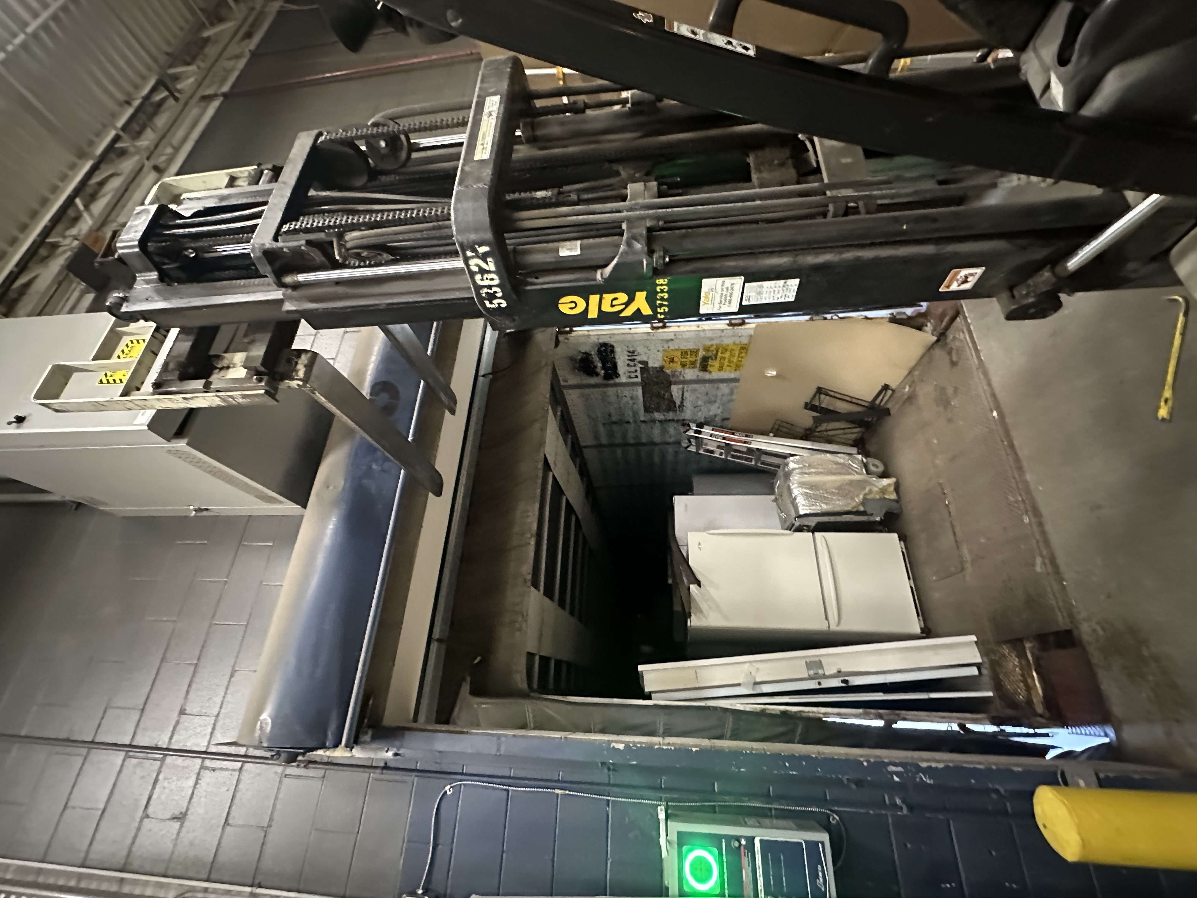 Commercial garage door installation using forklift to position heavy overhead door panels at warehouse